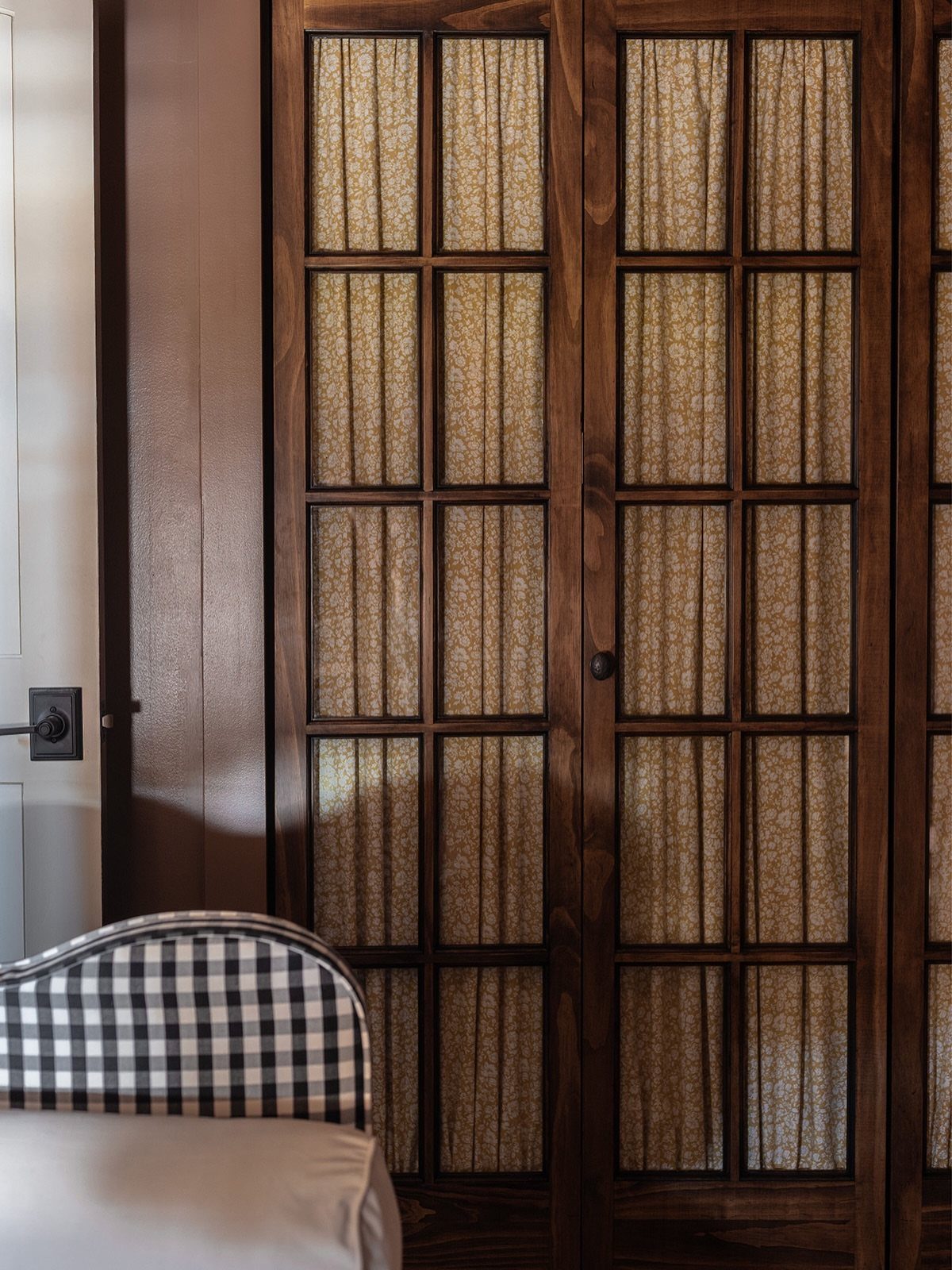 Dark wood sliding closet doors with grid patterns and translucent fabric panels.