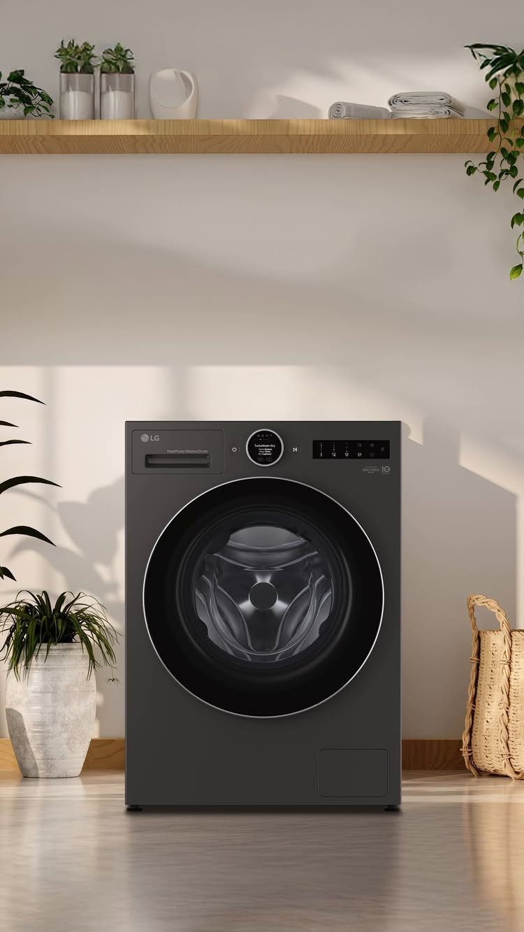 Dark grey front-load washing machine in a bright room with minimalist decor.