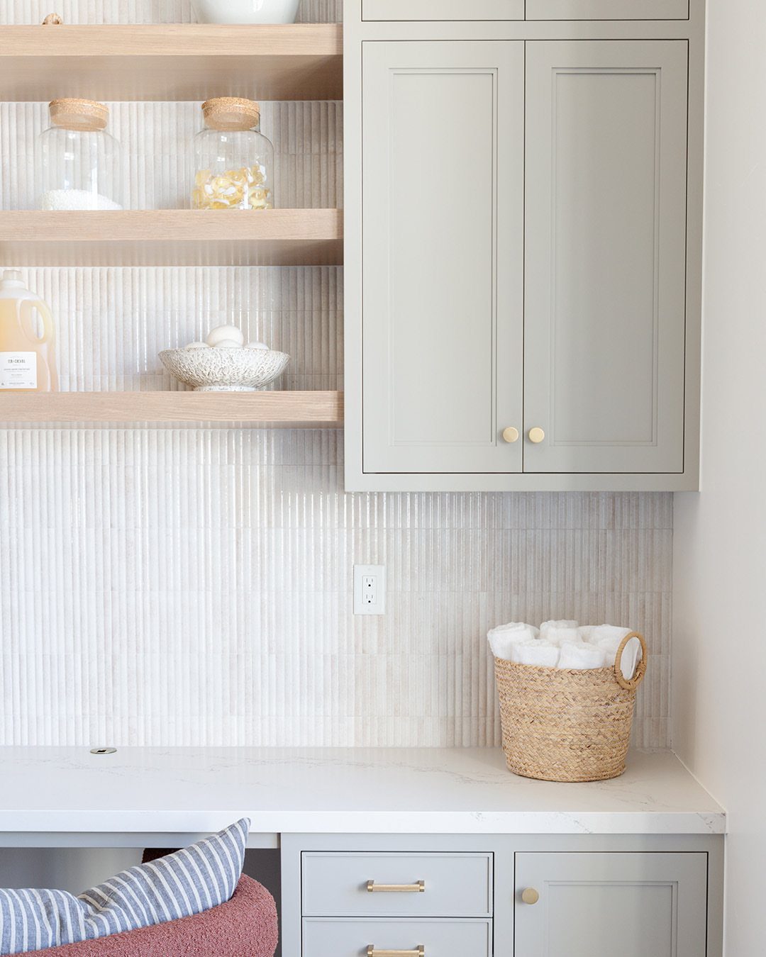White vertical kit-kat tile backsplash in a laundry room with grey cabinets.