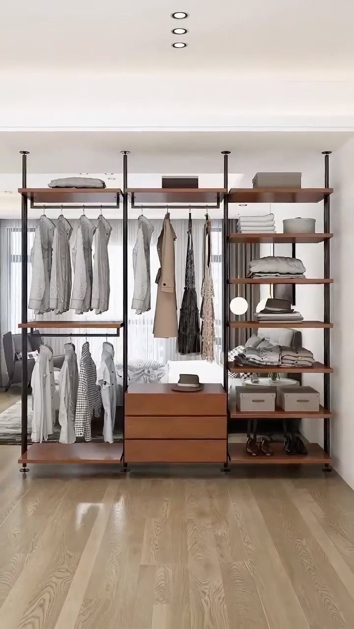 Open wooden and metal closet system with hanging clothes and storage drawers.