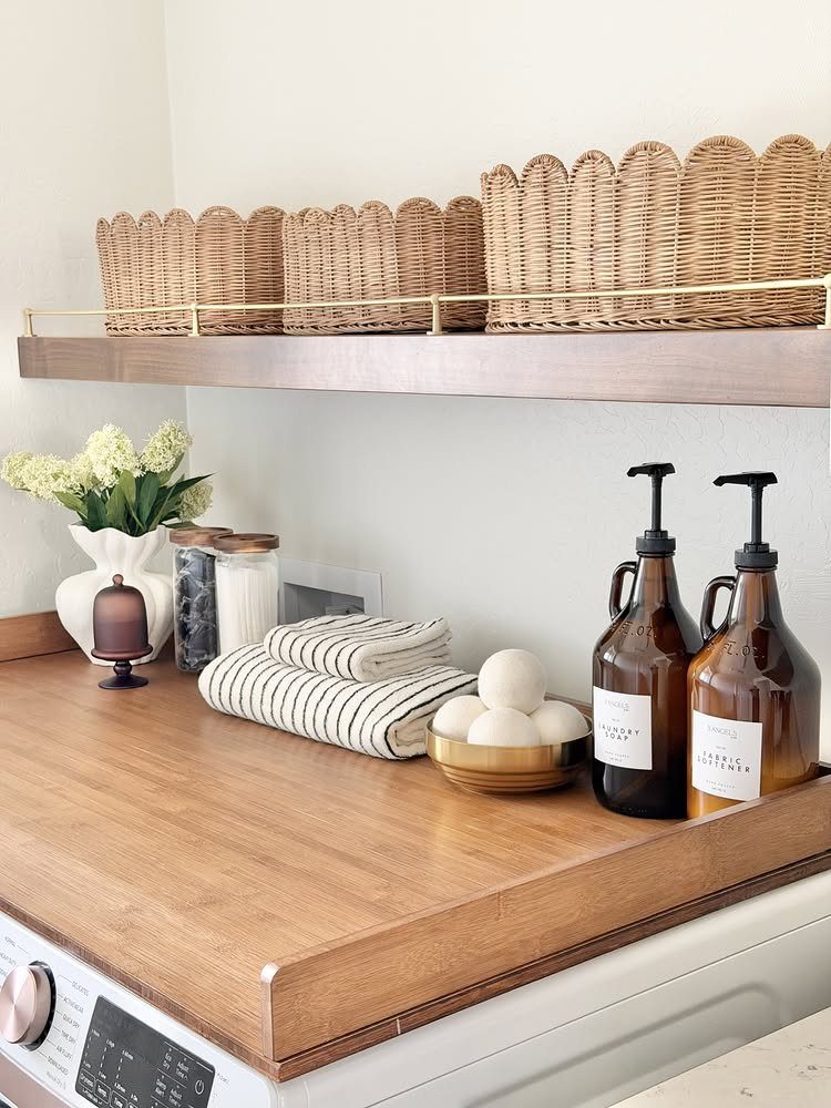 Woven wicker baskets on a wooden shelf above a laundry room countertop