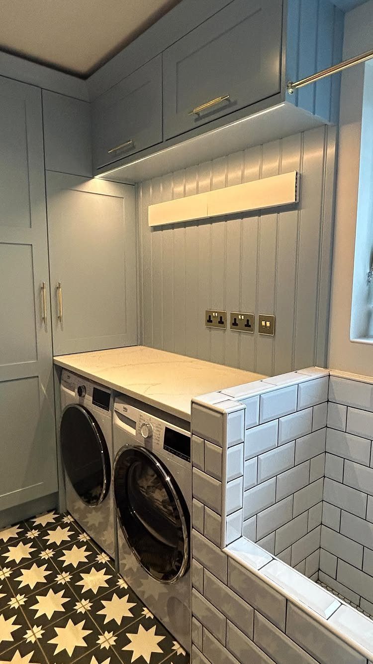 Light blue utility room with laundry appliances, white worktop, and patterned flooring.