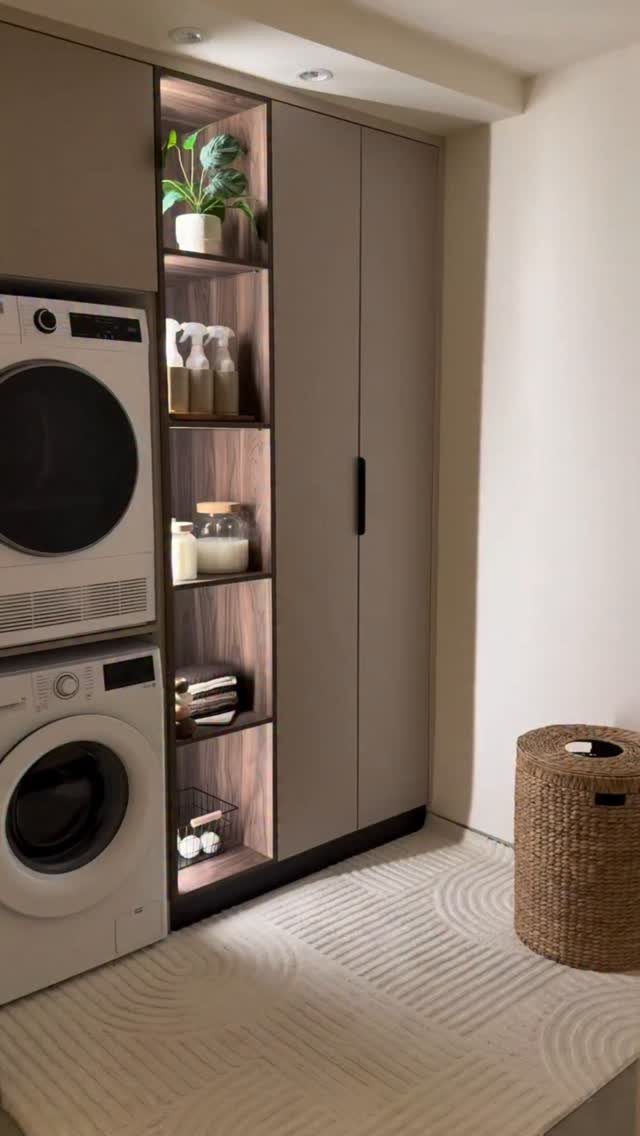 Stacked washer and dryer next to a shelving unit with integrated LED lighting.