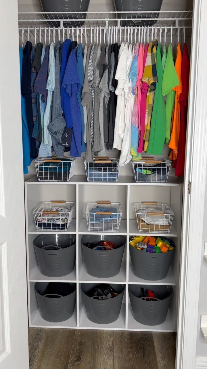 Closet organization with colorful shirts, under-the-shelf wire baskets, and white cube storage bins.
