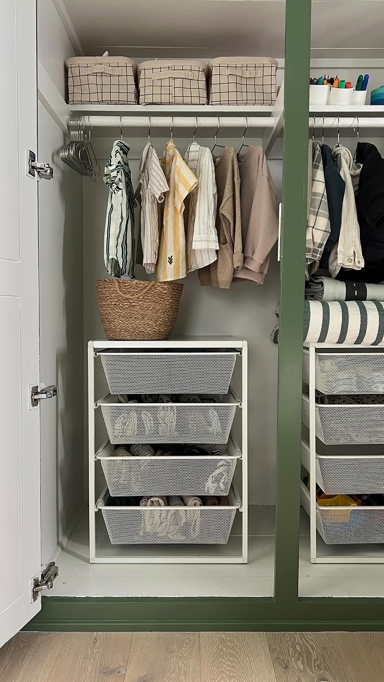 White closet with hanging clothes and a metal unit with wire mesh drawers.
