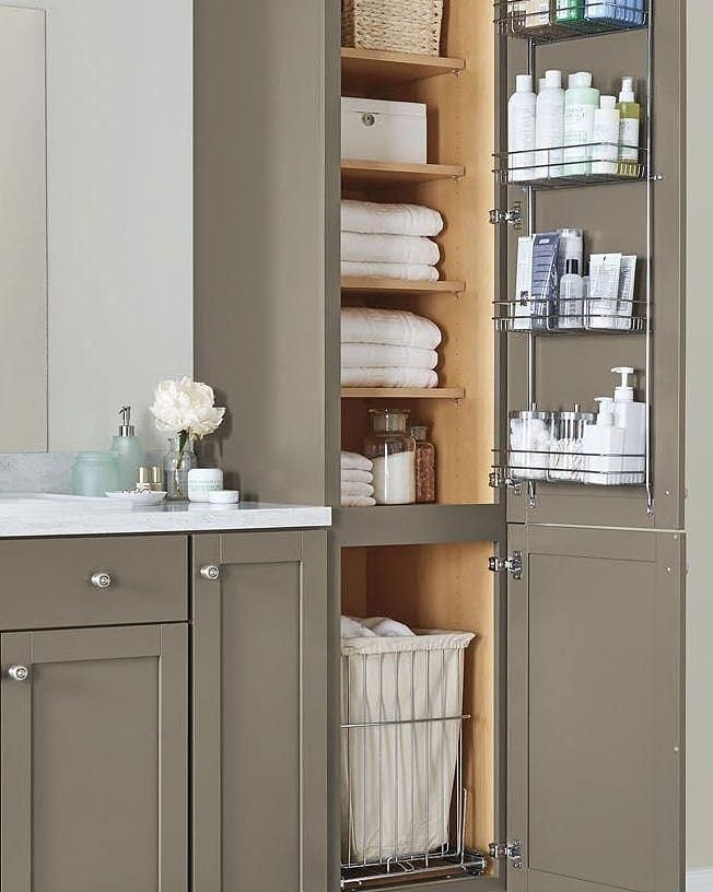Built-in bathroom closet with pull-out wire shelves and an integrated laundry hamper.