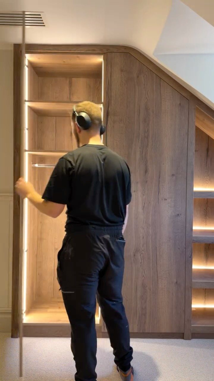 Built-in wooden closet with integrated lighting and a slanted top following the ceiling.