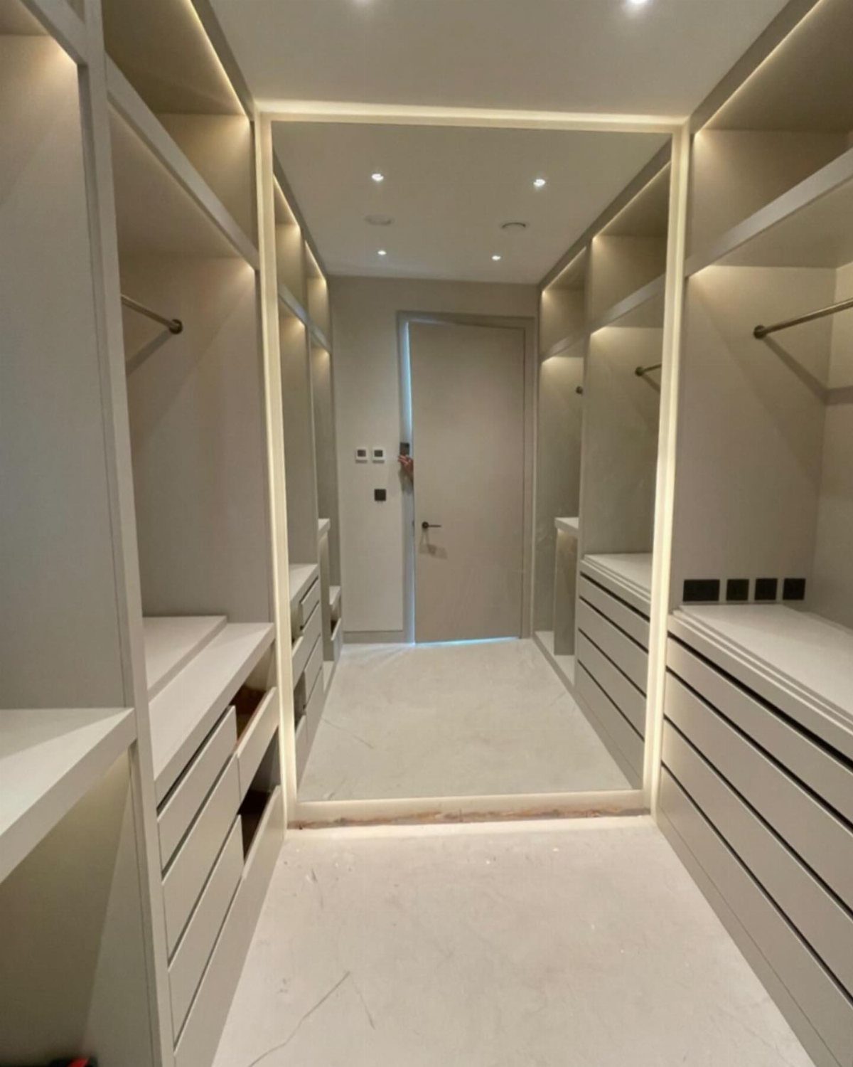 Large floor-to-ceiling mirror with LED lighting in a white contemporary walk-in closet.