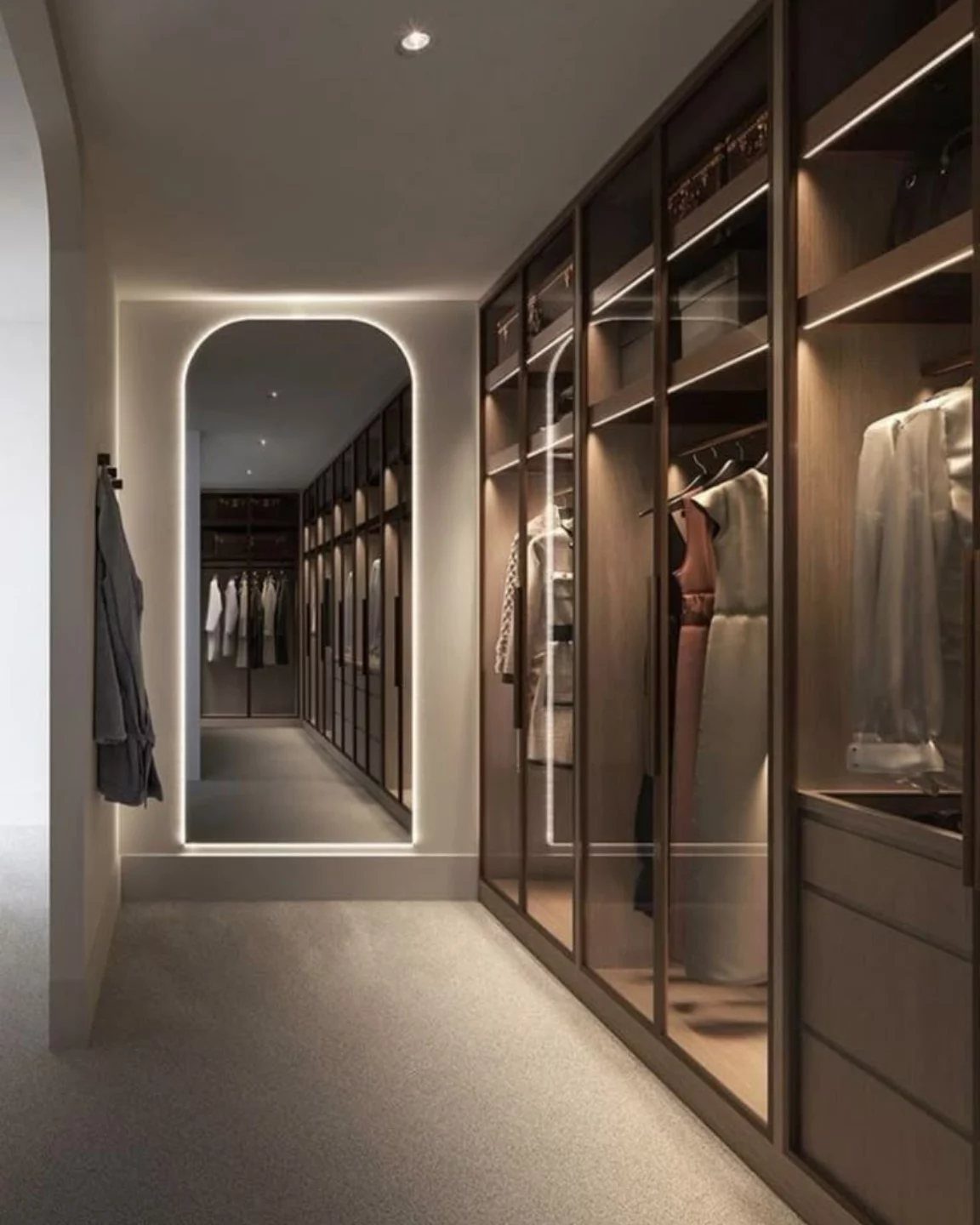 Modern walk-in closet with dark wood cabinets and shelves reaching the ceiling.