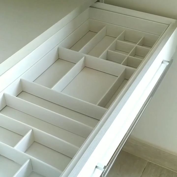 White pull-out closet drawer with built-in organizational dividers and compartments