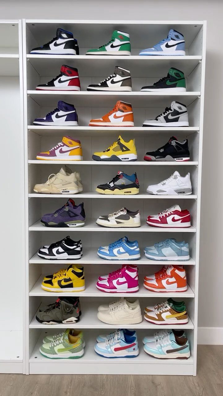 White shelving unit filled with rows of colorful sneakers against a white wall.