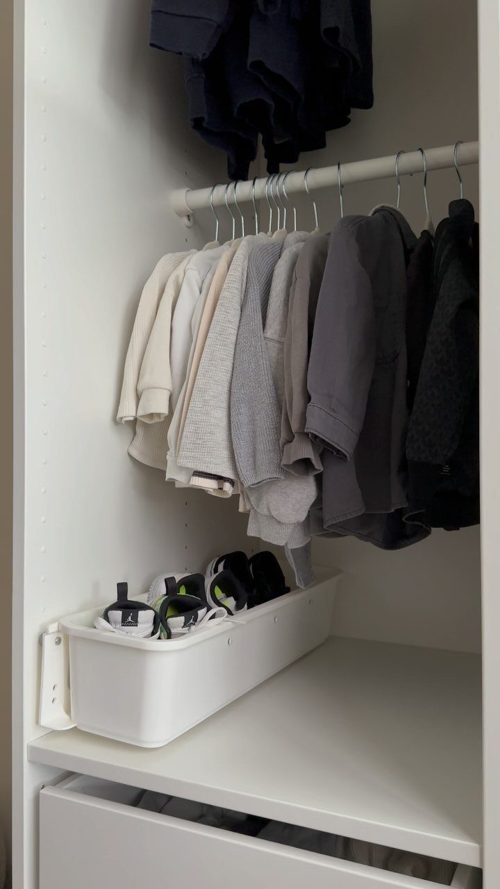 White plastic shoe bin attached to a closet wall holding several sneakers