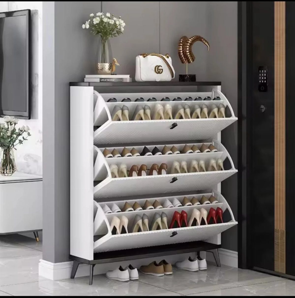 White tilt-out shoe cabinet holding high heels in a modern entryway setting