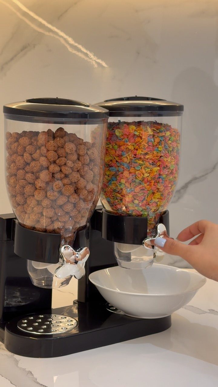 Cereal dispensers filled with brown and colorful cereal on a white marble countertop.