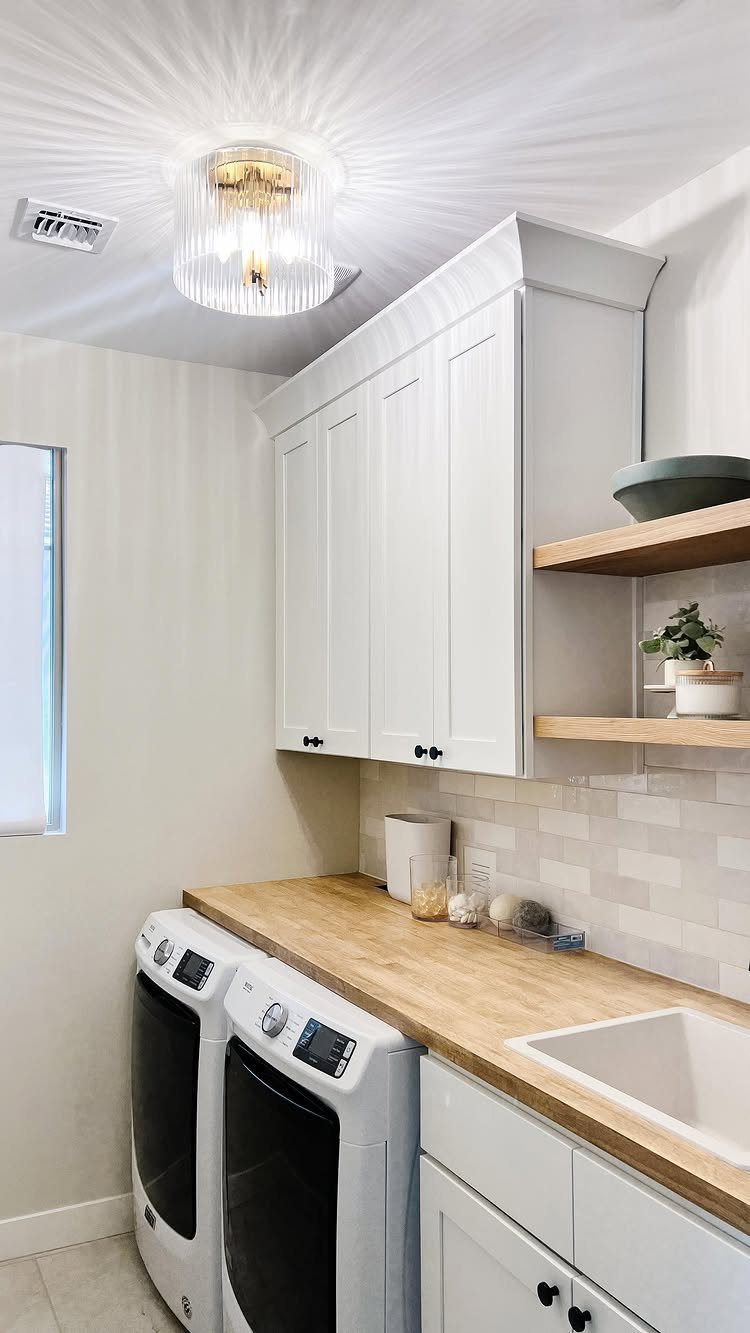 Gold and glass flush mount light fixture illuminating a white laundry room