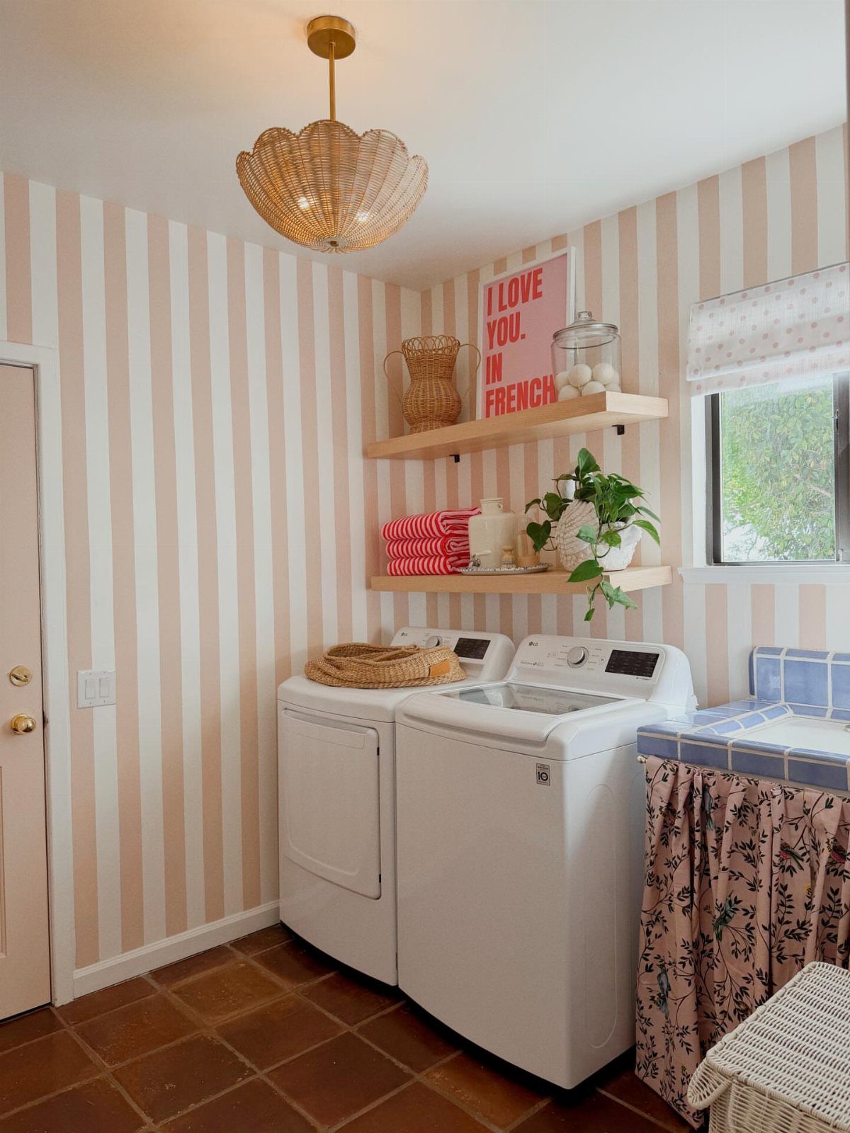 Laundry room with peach and white vertical painted stripes on the walls.