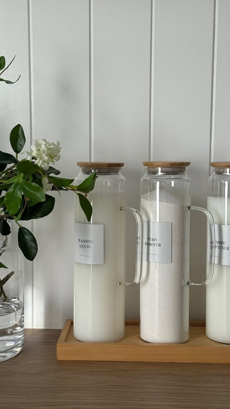 Glass jars with wooden lids filled with white powder on a wooden tray
