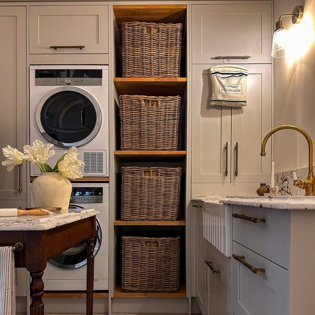 Four matching woven wicker baskets stored on wooden shelves in a laundry room.