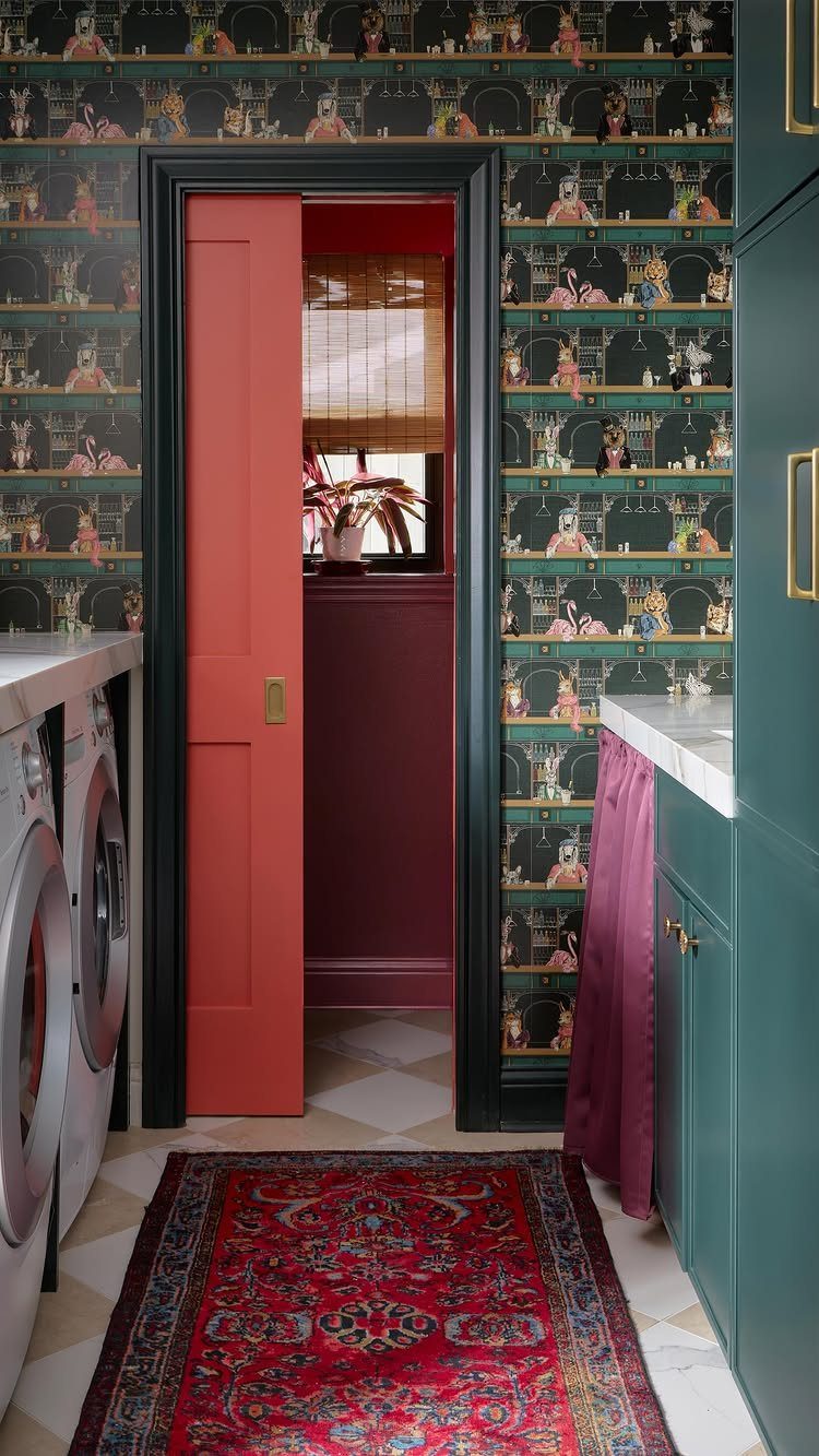 Dark green patterned wallpaper in a laundry room with teal cabinets and red accents.