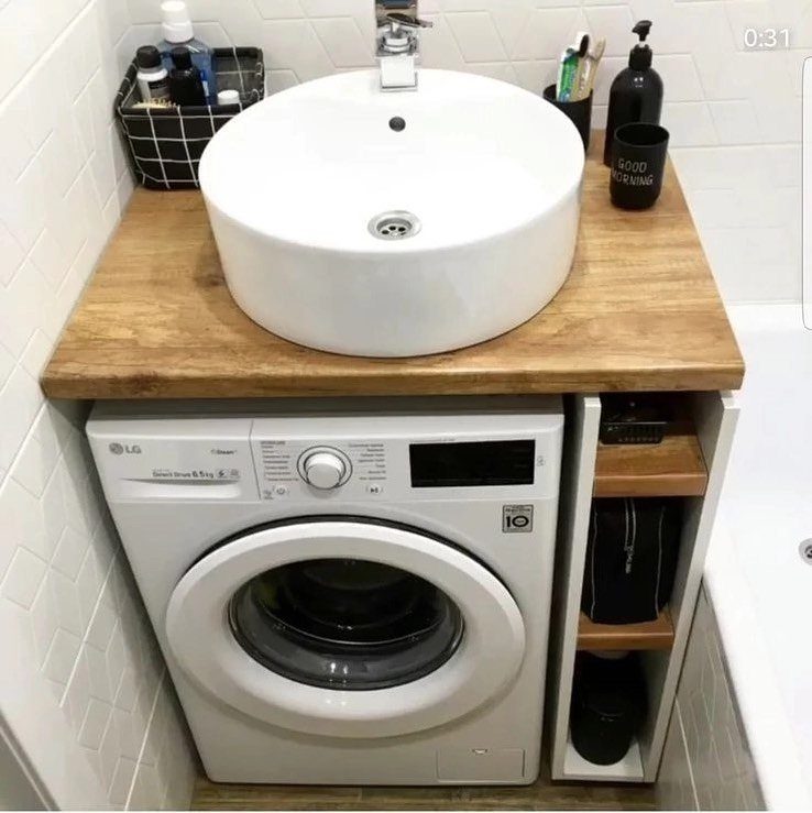 Small white washing machine installed under a wooden bathroom vanity with a vessel sink.