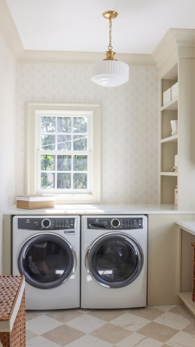 White washer and dryer with built-in shelving and a woven basket in laundry room