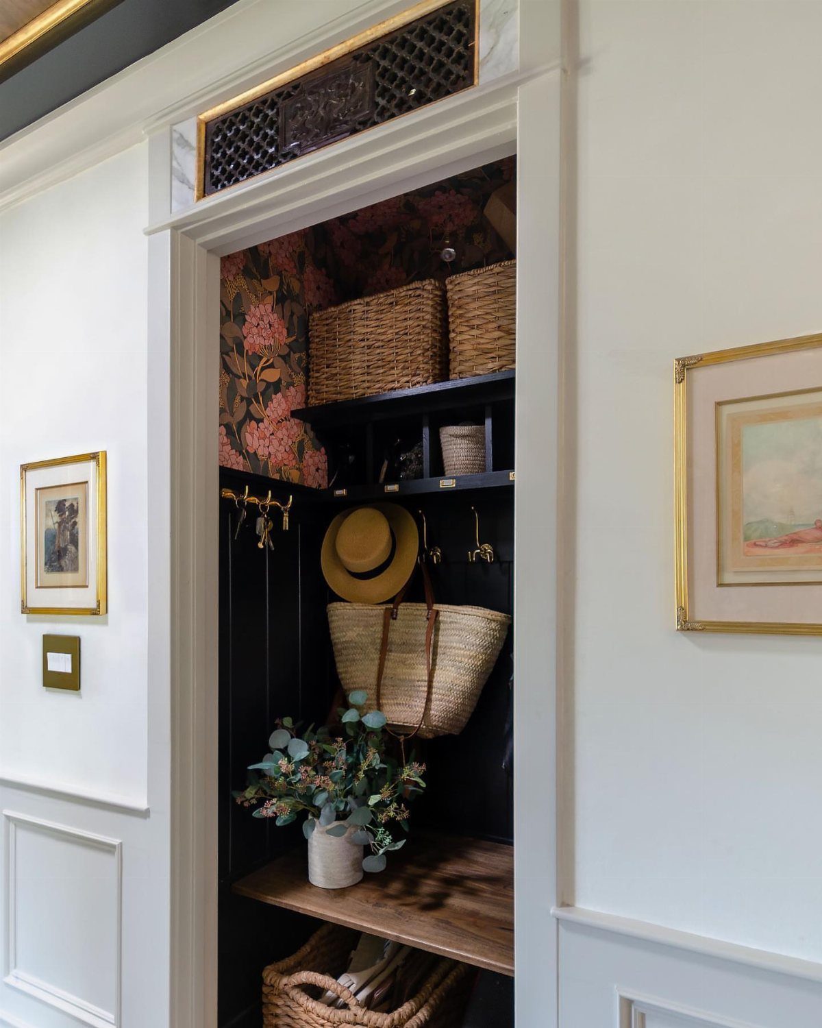 Closet mini mudroom with black walls, floral ceiling, wooden bench, and woven baskets.