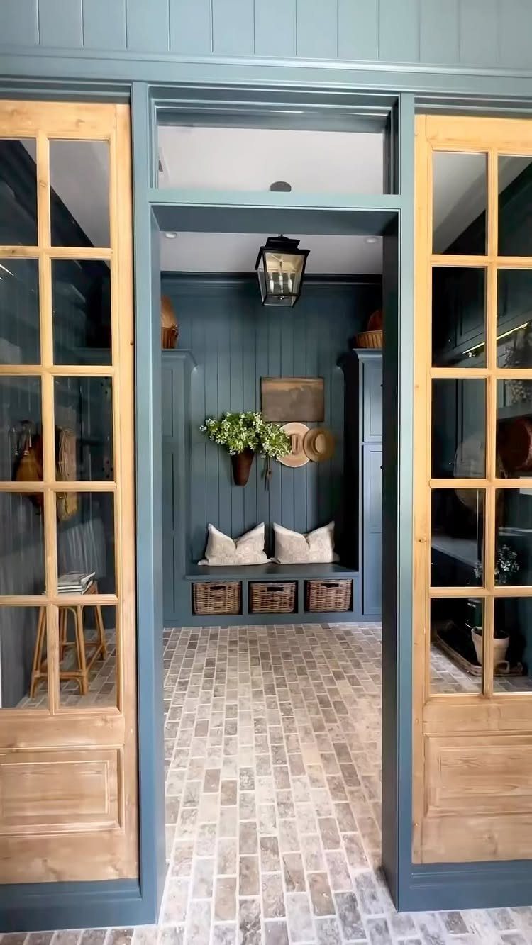 Light-colored rectangular tile flooring in a blue mudroom with built-in bench seating.
