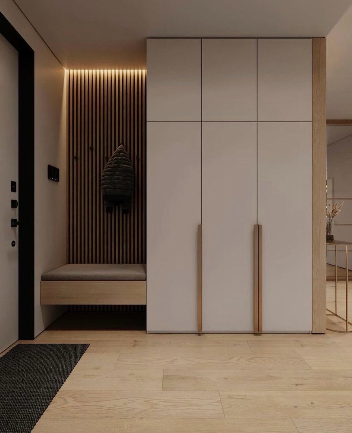 Modern mudroom with light-colored built-in cabinets, a wooden slat wall, and warm cove lighting.