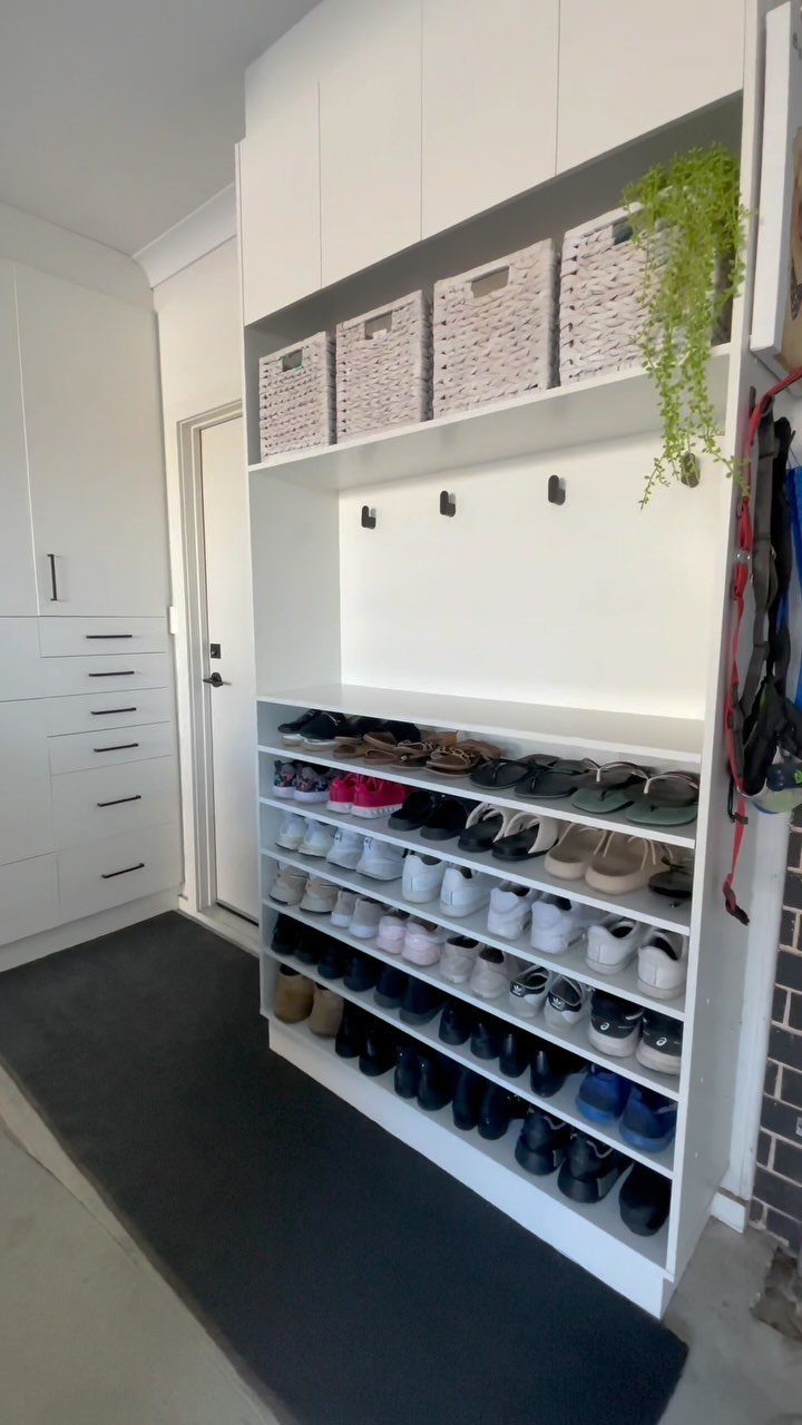 White built-in shoe rack and storage unit with a dark grey floor runner.
