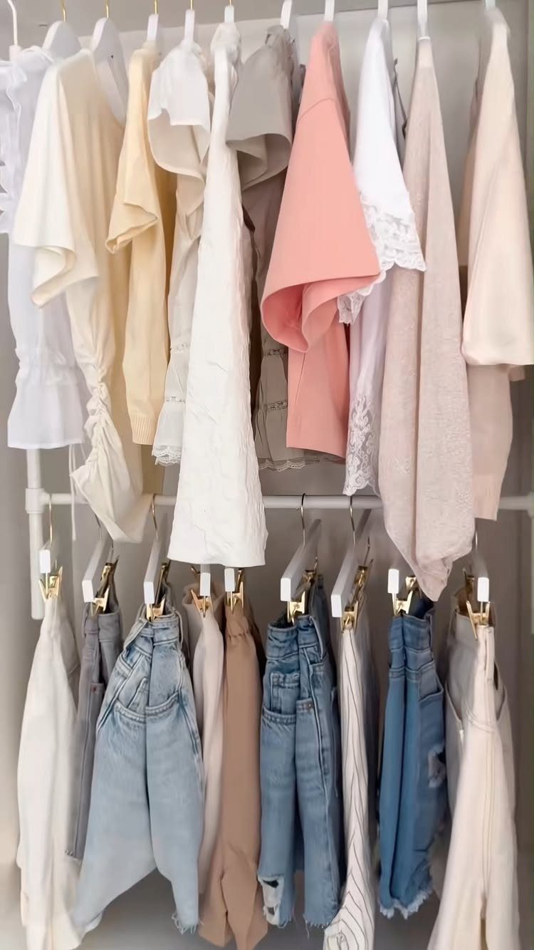Two levels of hanging rods with color-coordinated tops and denim jeans.