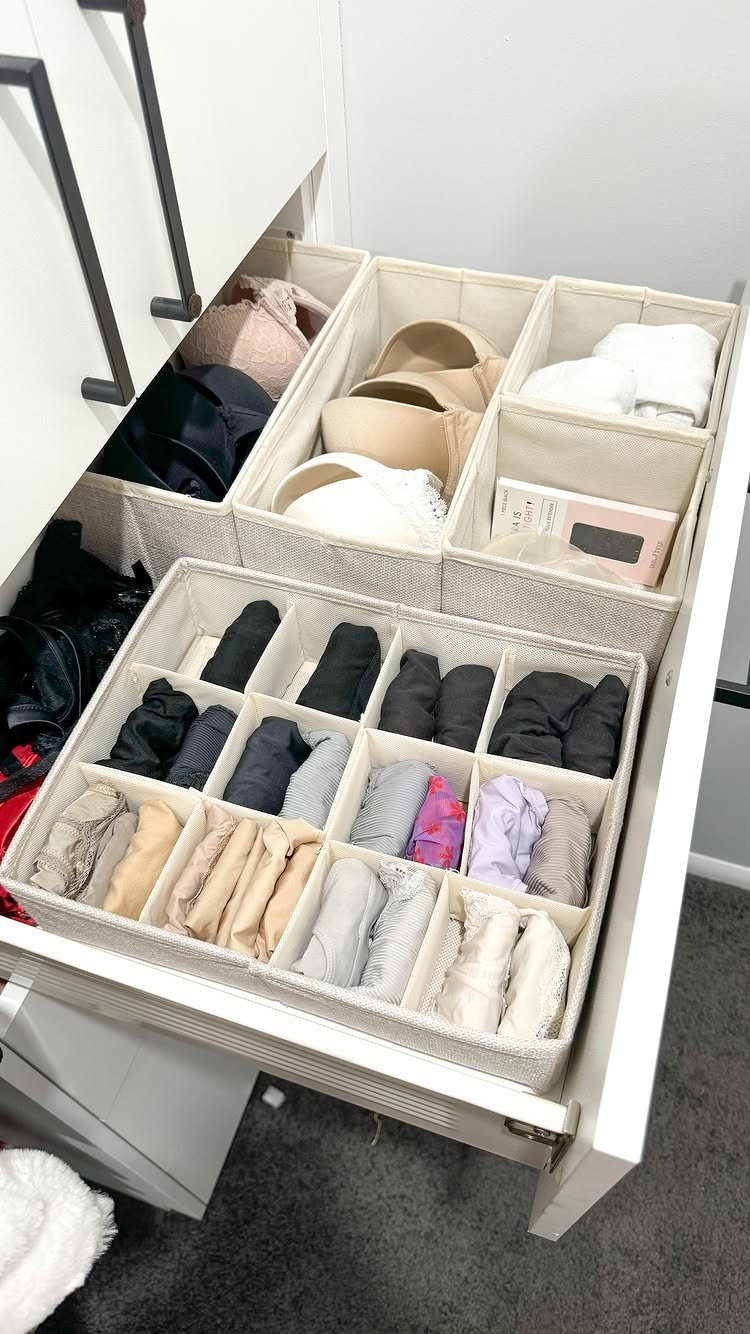 Drawer dividers organizing rolled socks and undergarments in a white closet dresser.