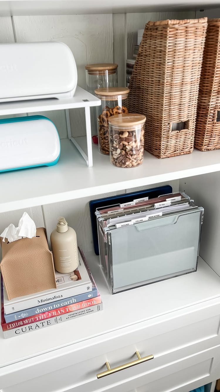 Clear plastic file organizer with labeled hanging folders on a white shelf.