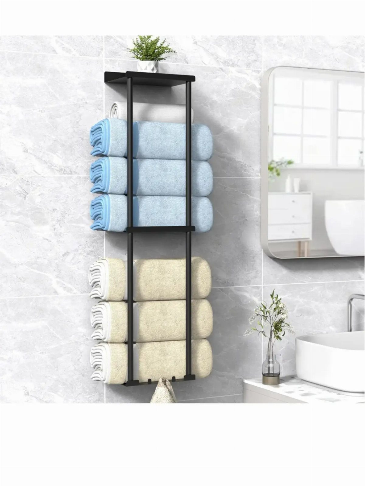Black metal wall-mounted towel rack with folded blue and beige towels on marble wall