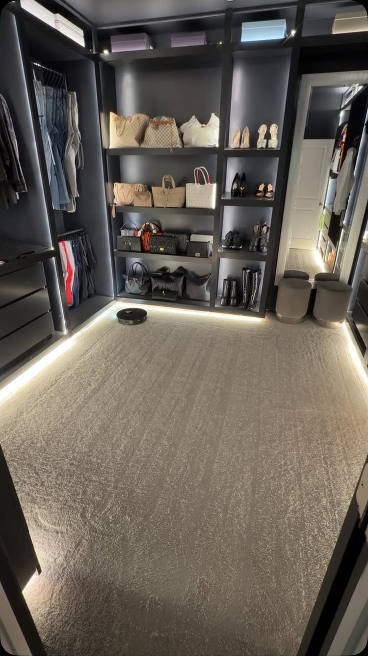 Modern dark grey closet with integrated LED strip lighting illuminating shelves and floor.