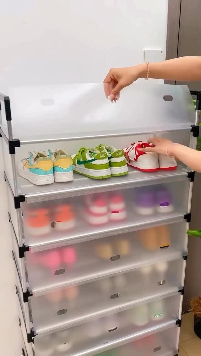 Clear plastic shoe storage drawers filled with colorful sneakers against a white wall.