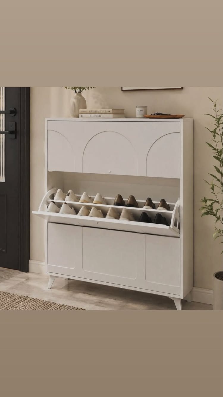 White shoe cabinet with an open flip-down drawer showing organized footwear.