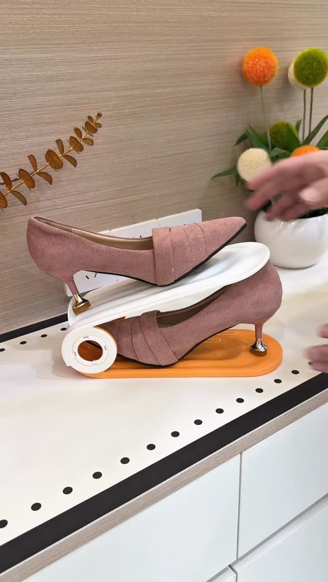 Pink high heels stacked vertically using a white plastic shoe storage organizer slot