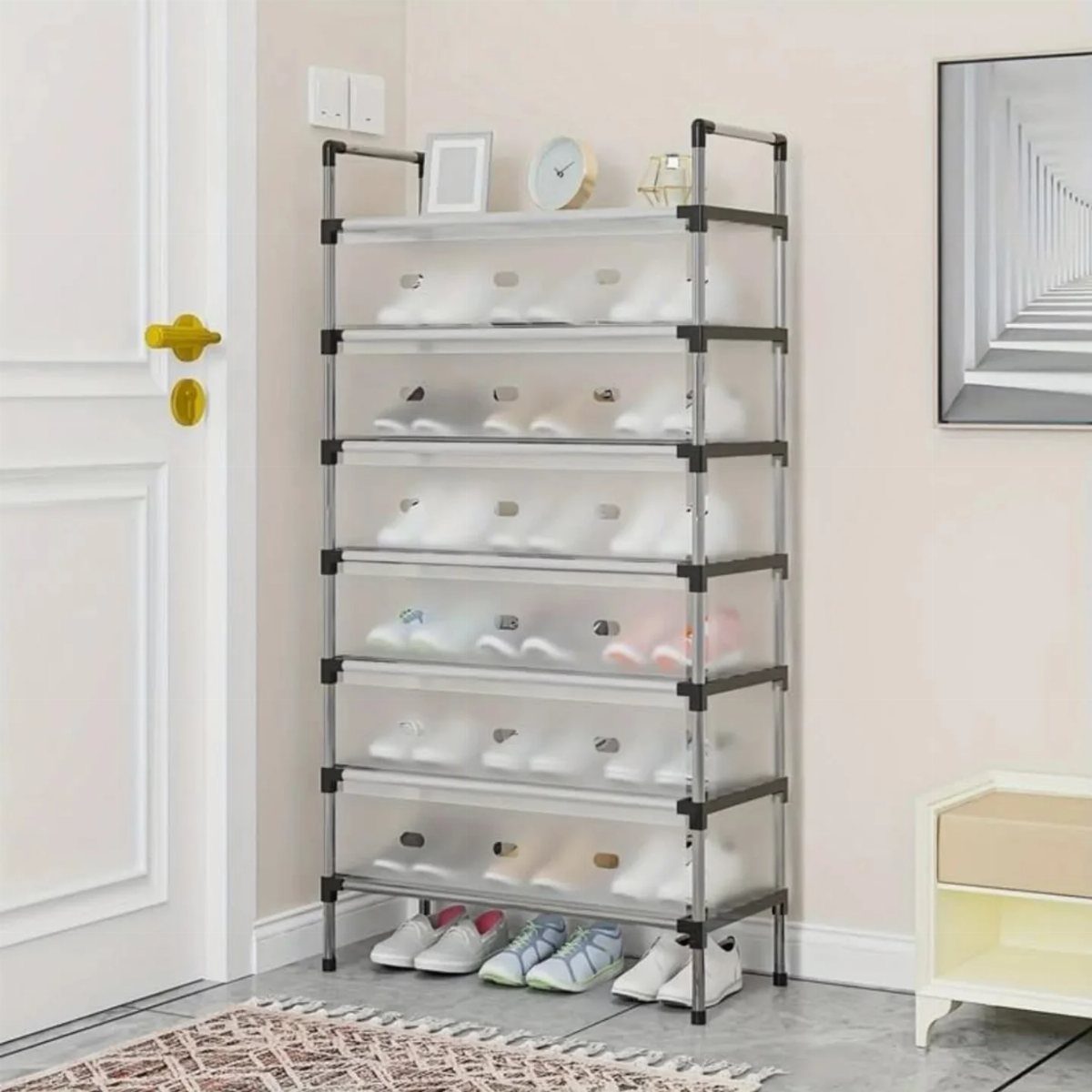 Vertical shoe rack with transparent drawers holding white shoes against a light wall.