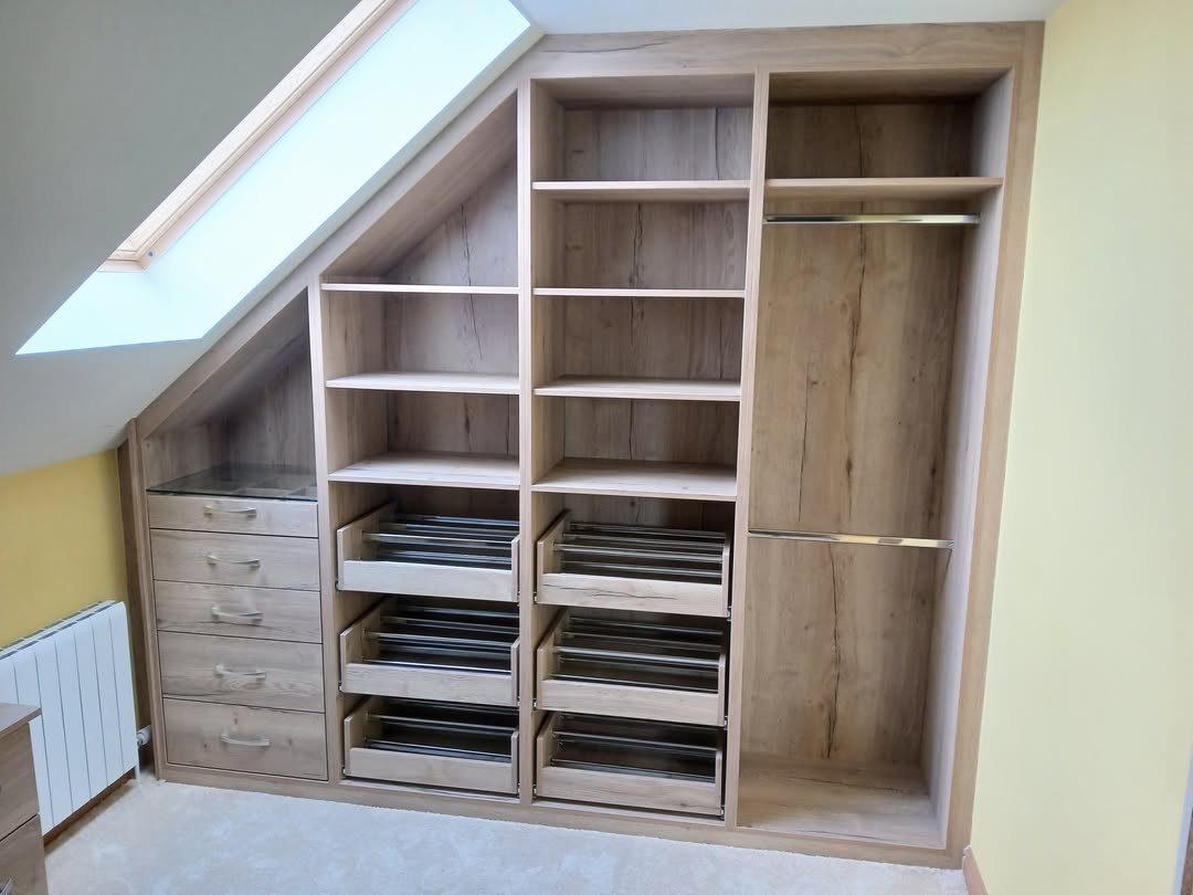 Light wood custom closet with pull-out shoe racks under a sloped ceiling.