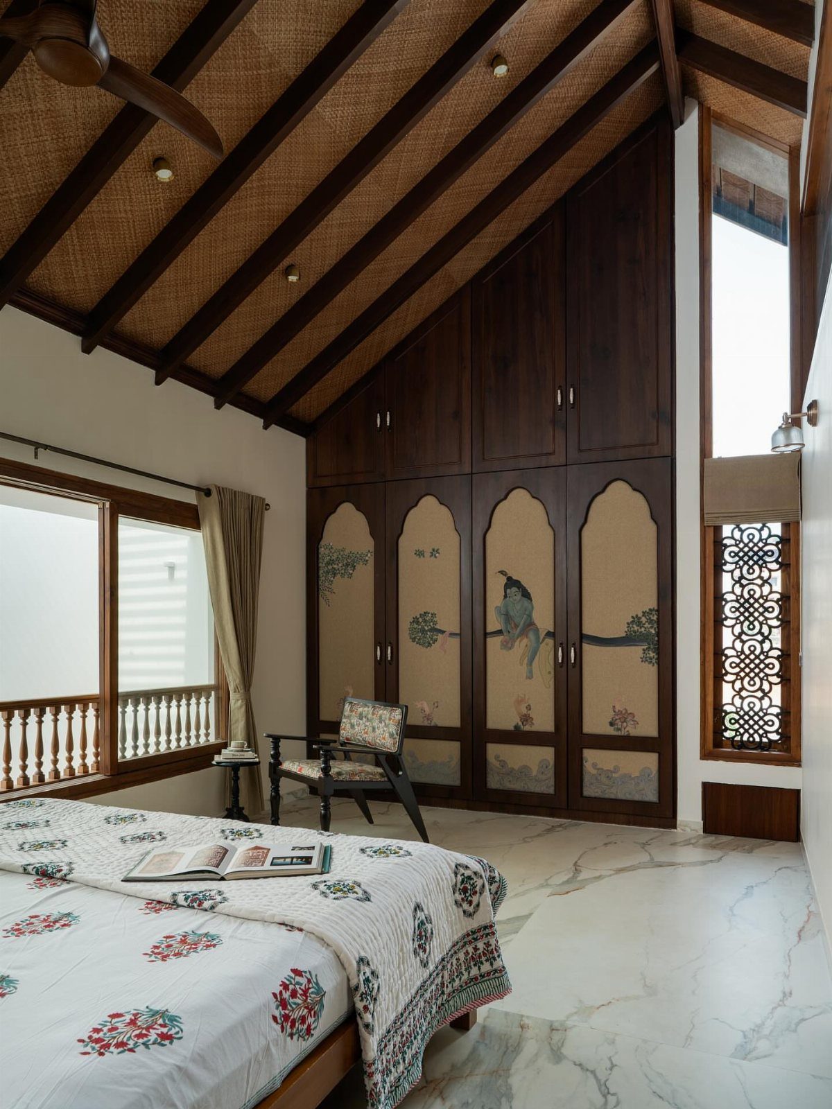 Large dark wood built-in wardrobe under a sloped wooden beam ceiling in bedroom