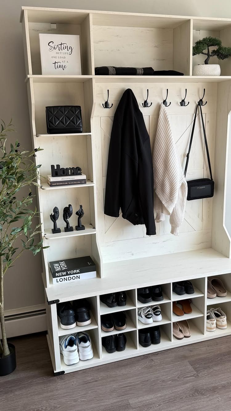 White wooden hall tree with hooks for coats and cubbies for shoe storage.