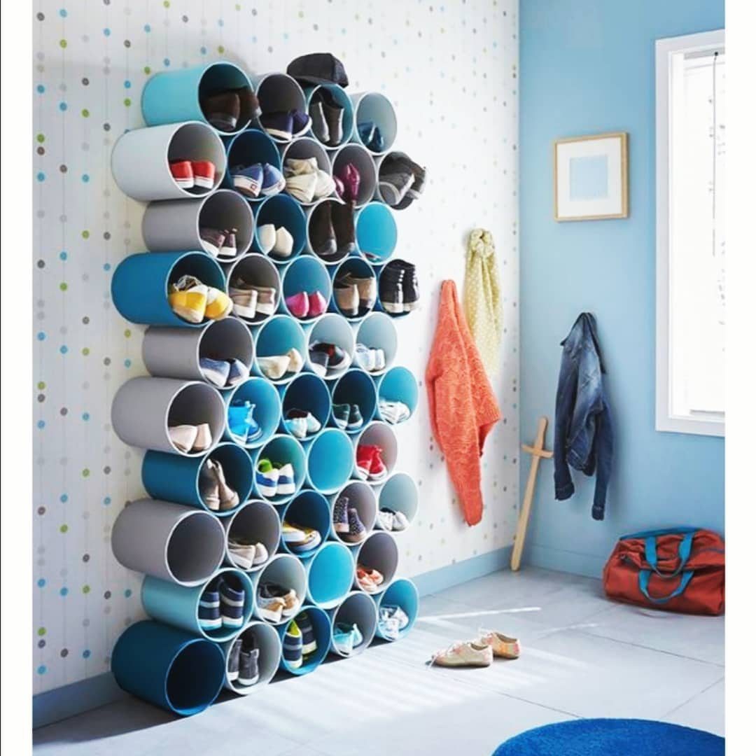 PVC pipe shoe organizer with blue and grey tubes mounted on a wall.