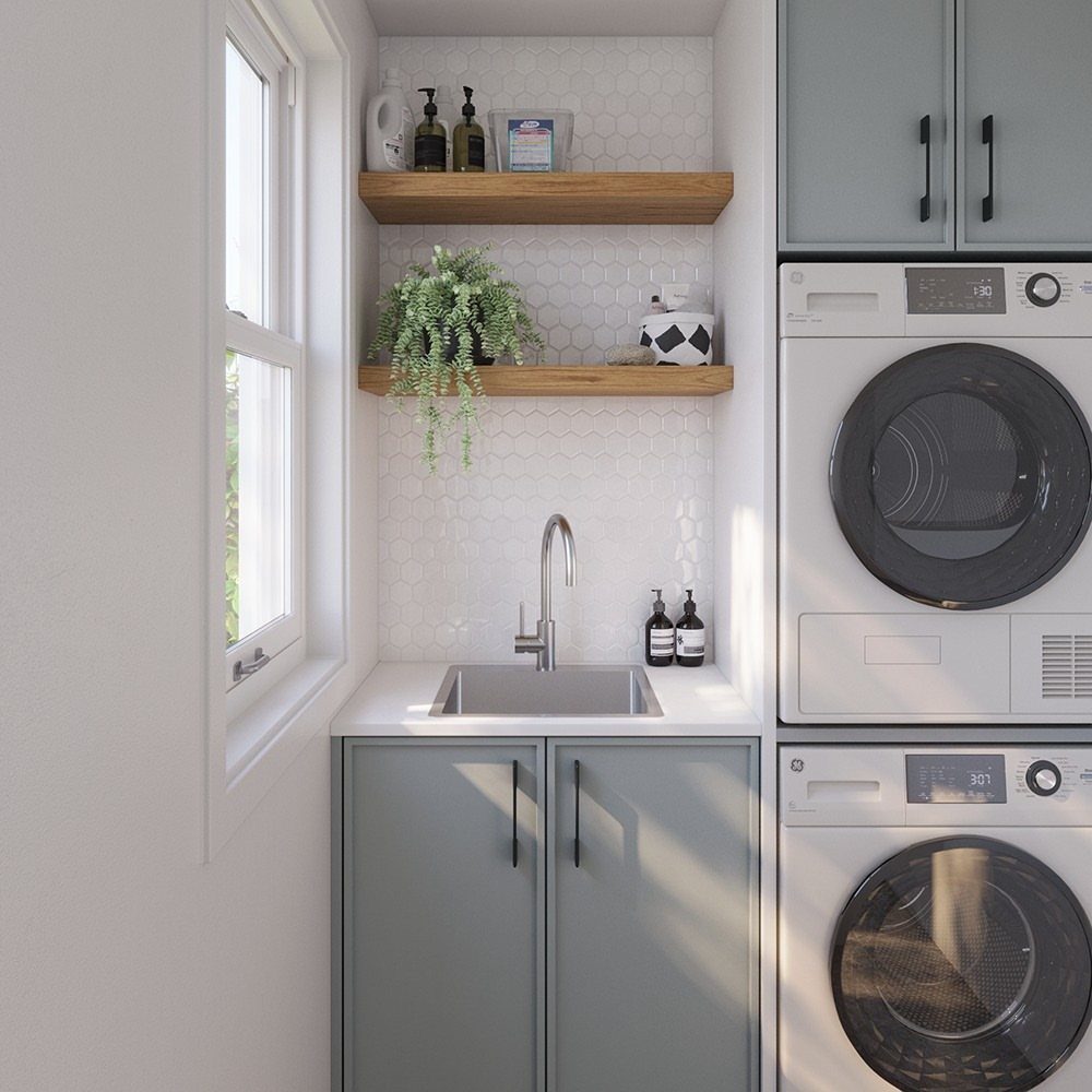 Small stainless steel sink with chrome faucet in a modern laundry room setup.