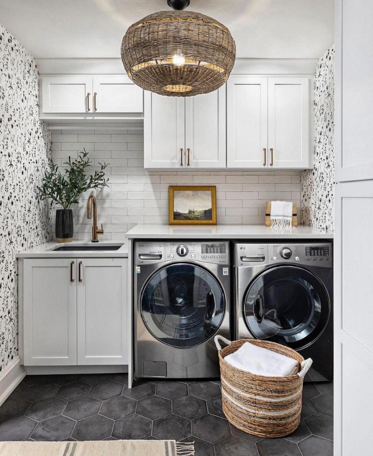 Woven wicker pendant light hanging in a modern white laundry room with silver appliances.