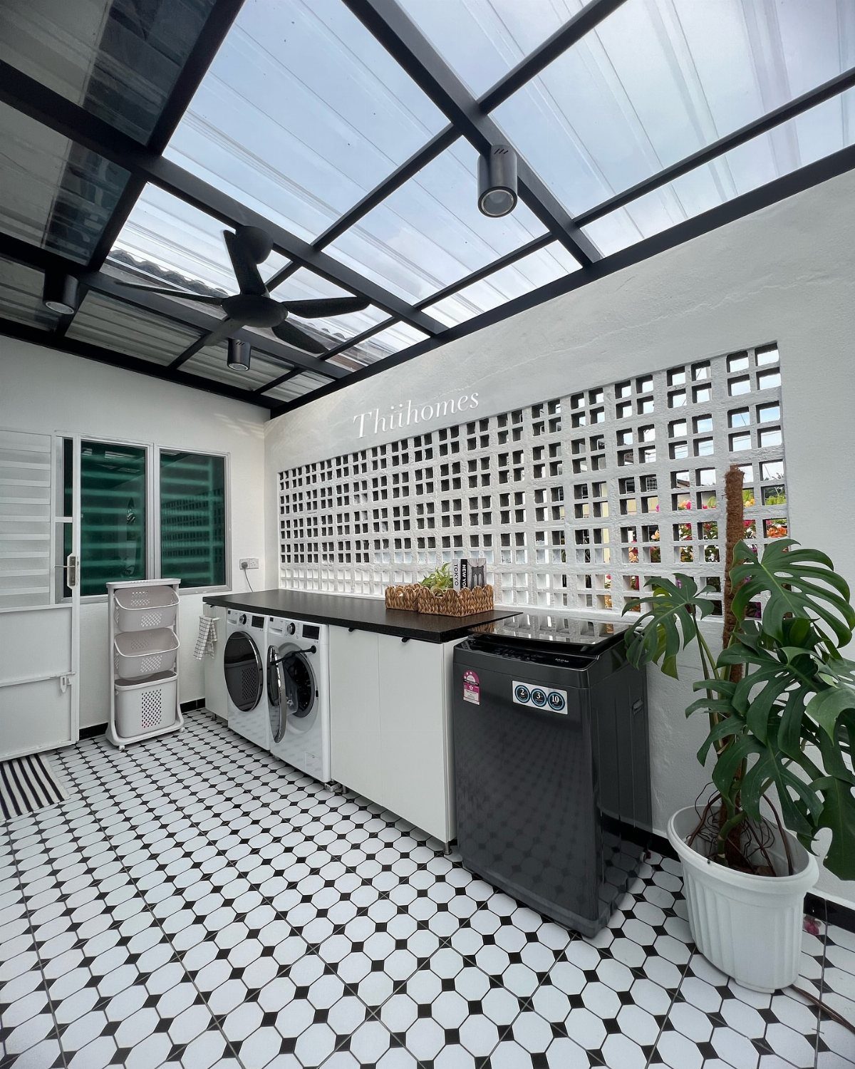 Laundry room with glass ceiling, white appliances, dark countertop, and patterned tile floor.