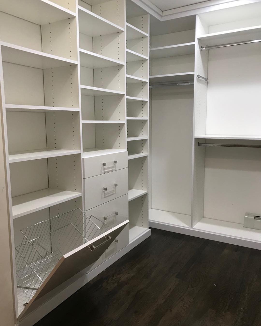 White walk-in closet system featuring a pull-out wire laundry hamper and open shelving.