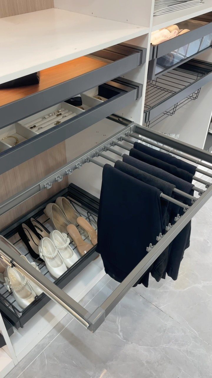 White walk-in closet with pull-out racks for trousers and high-heeled shoes.