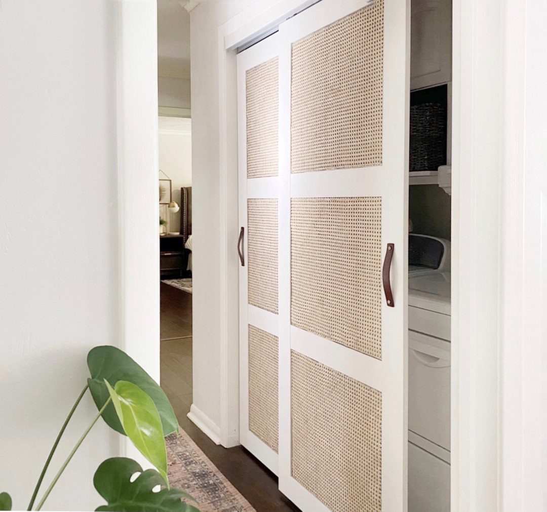 White sliding cane doors opening to a stacked washer and dryer in a hallway