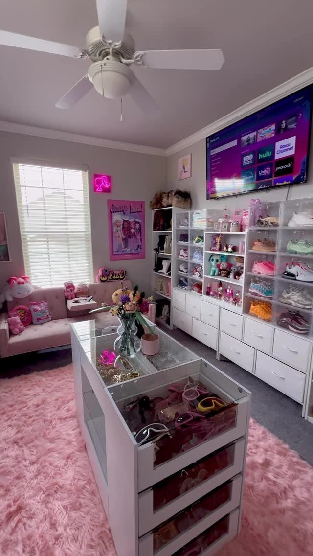 Converted bedroom closet with white shoe storage, pink rug, and glass-top island.