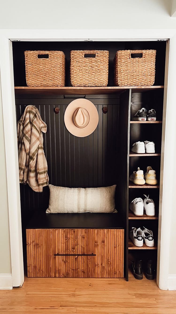 Converted closet mudroom with wooden bench, shoe shelving, and woven storage baskets.